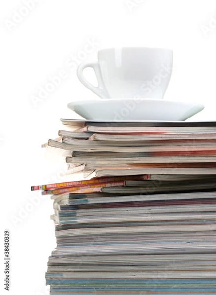 Fototapeta stack of magazines and cup isolated on white