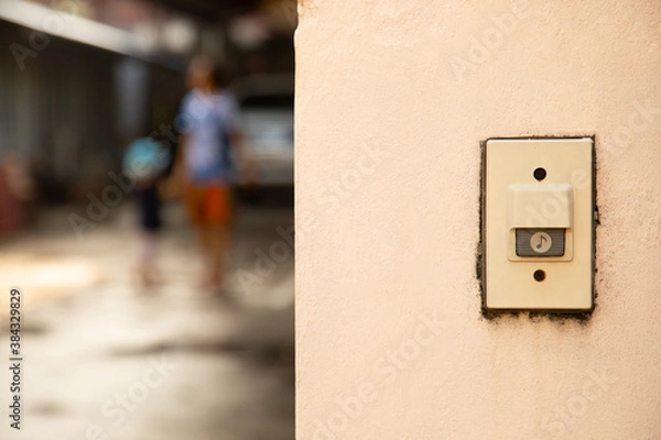 Fototapeta close up and front view of bell or buzzer is on the plaster wall in entry front of the house for security and safety to the resident. The copy space with blurred background is shown