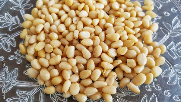 Obraz pine nuts on a plate against a dark background