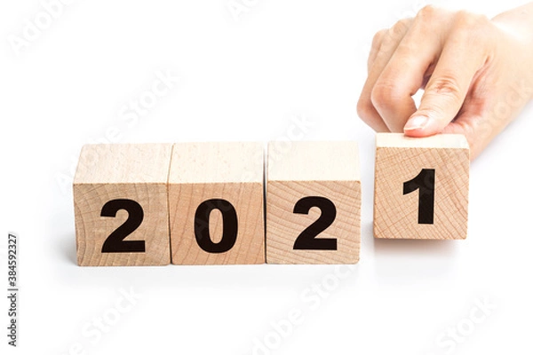 Fototapeta Hand flips a block changing 2020 to 2021. New year beginning. Holidays and Christmas.