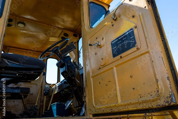 Fototapeta Closeup of a yellow tractor with russian instructions for using the levers