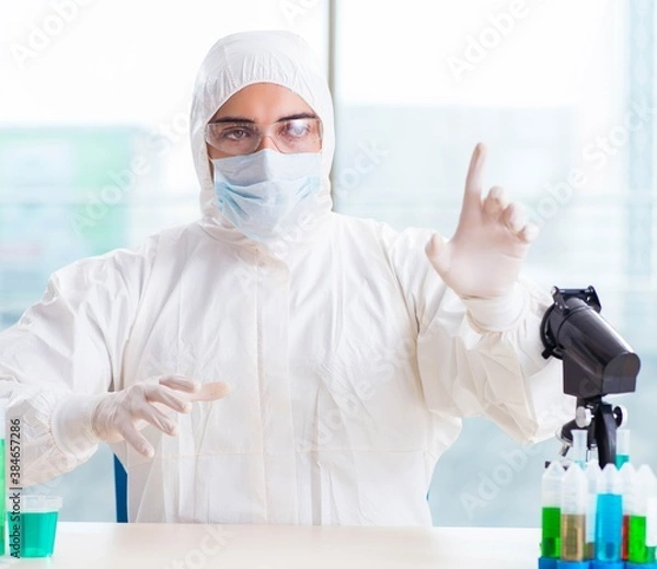 Fototapeta Young chemist pressing virtual buttons in lab