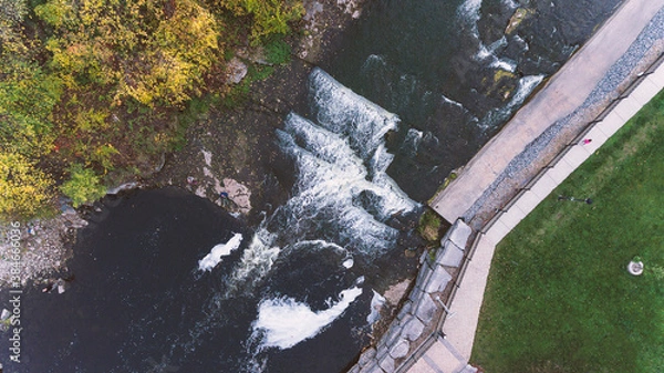 Fototapeta Springside Park waterfall from above in an aerial view with autumn and fall colours in the town of Greater Napanee Ontario.