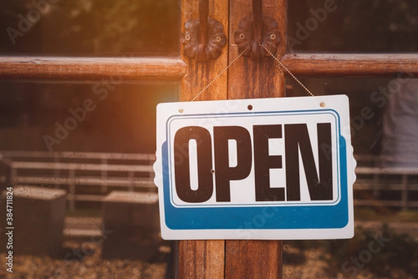 Fototapeta Text on white sign board  “ open" was hung on the glass’s shop with the   vintage background. The glass was a bit dirty and dusty tone.