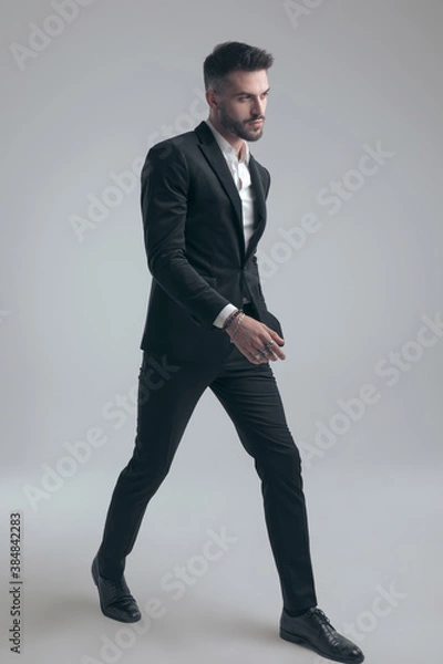 Fototapeta Charming elegant man wearing suit and walking
