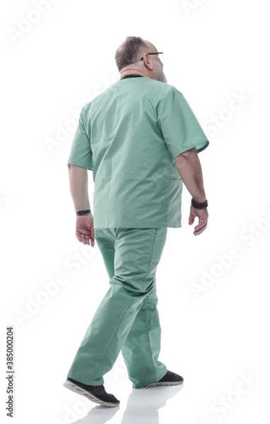 Obraz in full growth. Mature doctor with a stethoscope confidently stepping forward