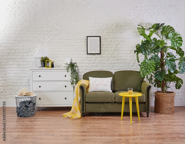Fototapeta Classic green sofa and yellow coffee table, white cabinet in the room and plant style.