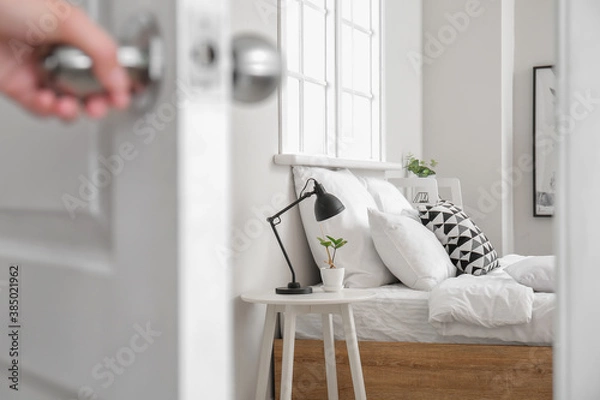 Fototapeta Woman opening door in modern bedroom