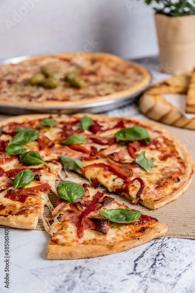 Fototapeta delicious homemade pizza with sauce, cheese ready to eat on white marble