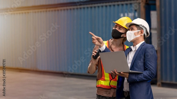 Obraz Inspector talking with female dock worker used laptop checking cargo freight. Businessman consult with engineer about transport container in shipping yard. logistics and transportation concept.