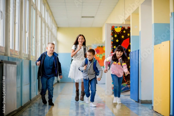 Fototapeta Group of children running through the hall of a school
