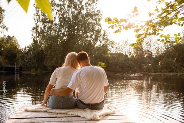 Fototapeta A man and a woman sit on the dock