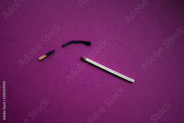 Fototapeta burnt match broken in half and whole match on purple background
