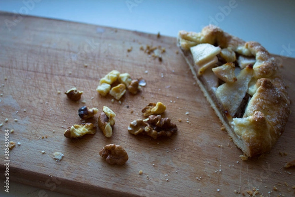 Fototapeta a piece of pie with aplle and nuts on a wooden plank