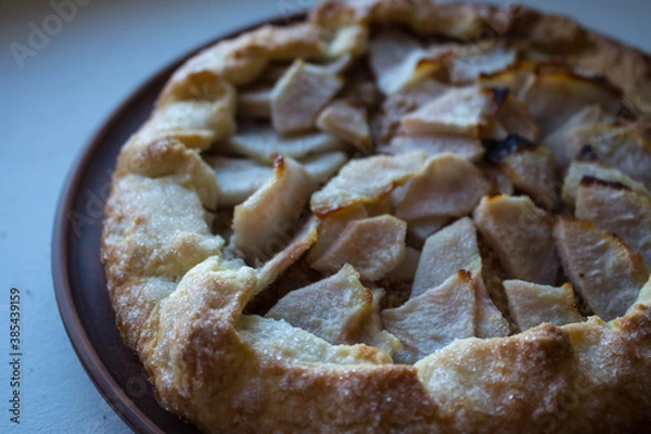 Fototapeta a apple pie on a clay plate on white background