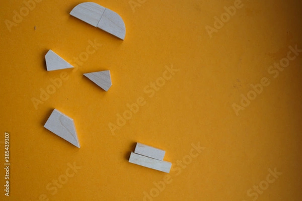 Fototapeta a wood puzzle on a yellow background