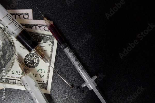 Fototapeta The use of drugs. Syringe with prepared heroin and money dollars on a dark background.