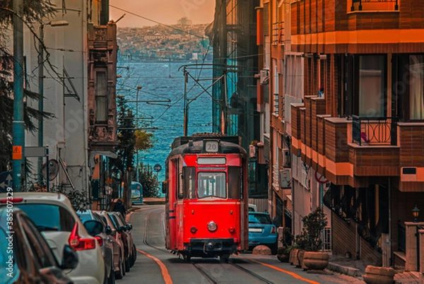 Fototapeta Old nostalgic tram going through the streets of Kadikoy district on the Asian side of Istanbul. The trendy neighborhood is full of colorful buildings. Marmara Sea.