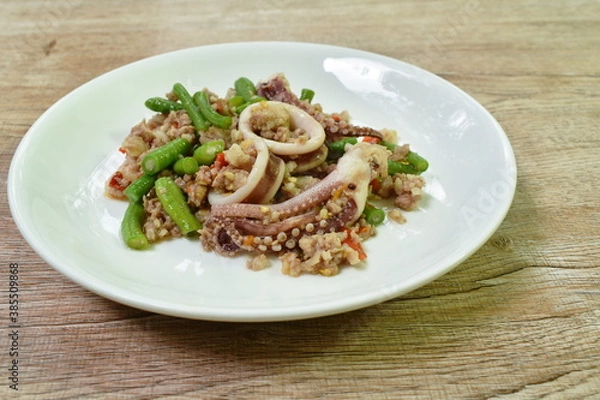Fototapeta spicy fried chili squid with chop pork and basil leaf couple slice yard long bean on plate