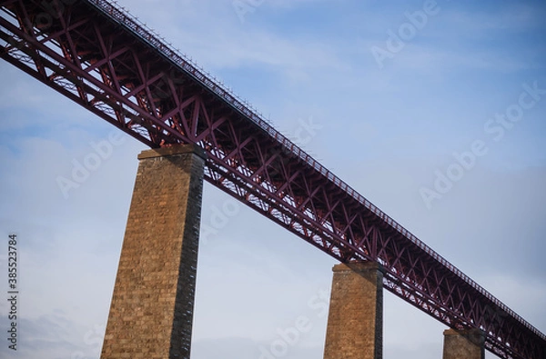 Fototapeta bottom up view of the railway bridge, evening sun, blue sky