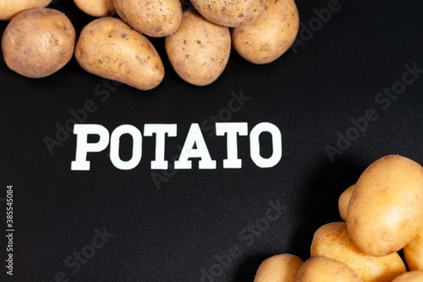 Fototapeta In the lower right and upper left parts of the screen there are small piles of unpeeled fresh potatoes.