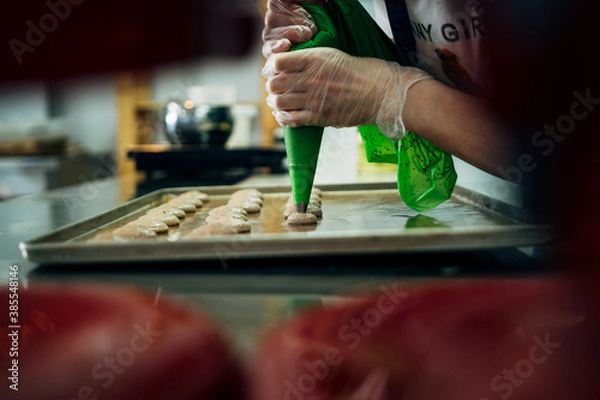 Fototapeta onfectioner making macaroons in pastry shop