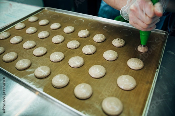 Fototapeta onfectioner making macaroons in pastry shop