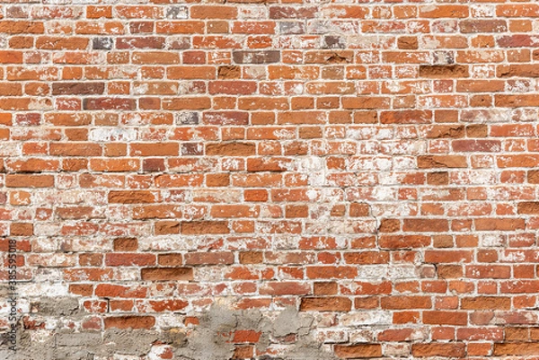 Fototapeta Weathered red brick wall, background with copy space for text. Texture or effect of old building, urban or loft style. Grunge facade for exterior. Rough surface with worn old stones and cracks