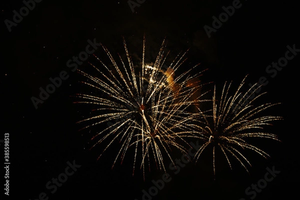 Fototapeta New Year celebration fireworks. Fourth of July Fireworks. Fireworks light up the sky with dazzling display. glowing fireworks show