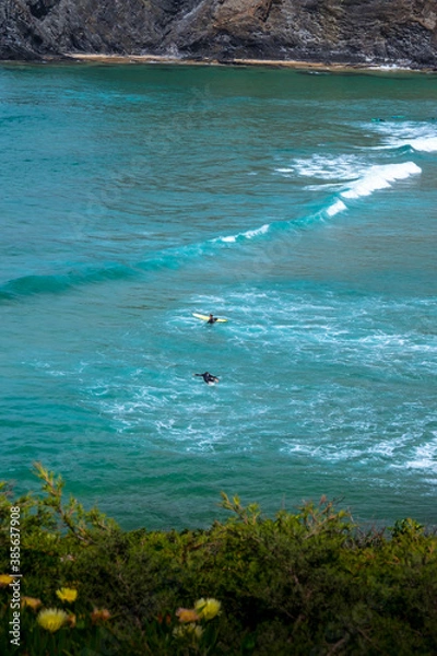 Obraz A view to the Atlantic Ocean where you can see the silhouettes of surfers catching the waves 
