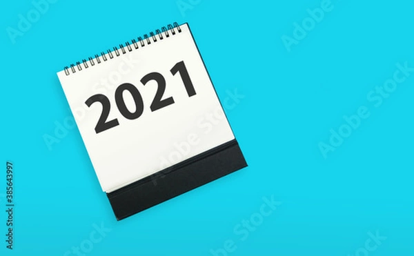 Fototapeta New year 2021 concept: flat lay of desktop calendar isolated on blue
