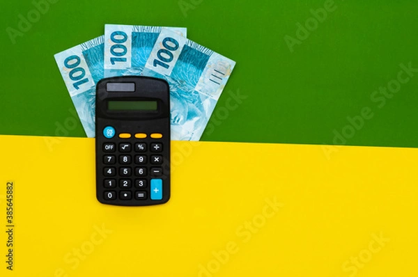 Obraz Brazilian money in wallet, with notepad and calculator. Finance and salary concept. Economy of Brazil. Green and yellow background. Three hundred reais
