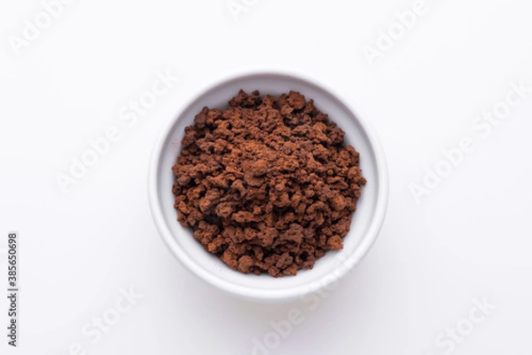 Fototapeta Instant granulated coffee from in a coffee cup on white background
