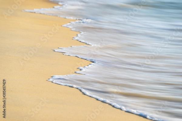 Obraz Miękkie fale morza na piaszczystej plaży w tle.