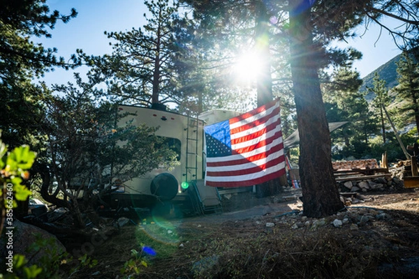 Fototapeta American flag backlit in RV campground wide shot