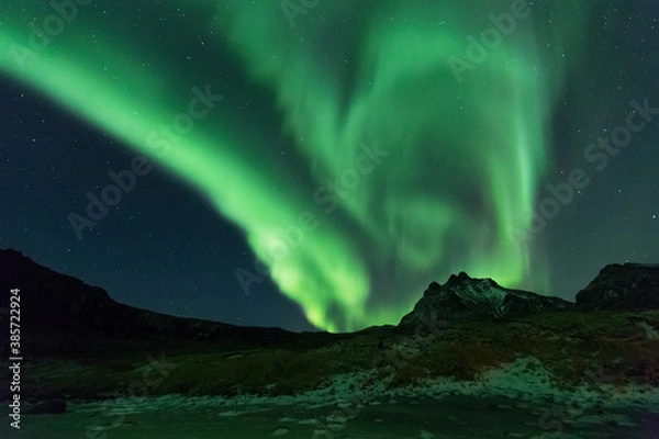 Fototapeta Beautiful night sky with Aurora Borealis aka northern lights in the fjords in Norway.