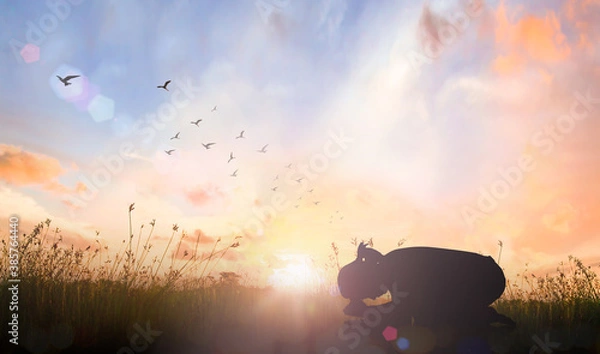 Obraz Easter Sunday concept: Silhouette of prayer woman bow down and praying over autumn sunset background