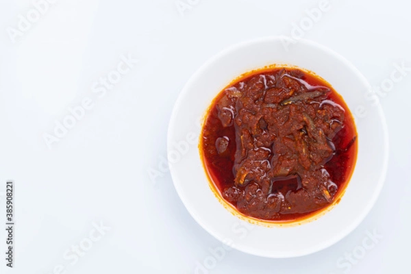 Fototapeta Top angle of "Sambal ikan bilis" suitable for nasi lemak or nasi impit Asian Inspirations, Stir-Fried Anchovies with hot chilies. A white background provides copy space to the left.