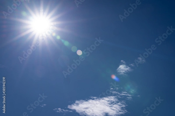 Obraz sunny background, blue, almost cloud-free sky with sun rays and flare