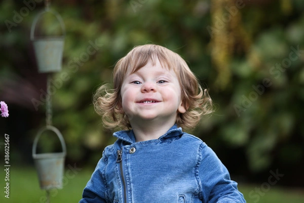 Obraz Close Up Portrait of a little 18 Month Old Girl with  Big Blue Eyes and Curly Hair, a girl Playing Outside, Funny Face Expression, Happy baby