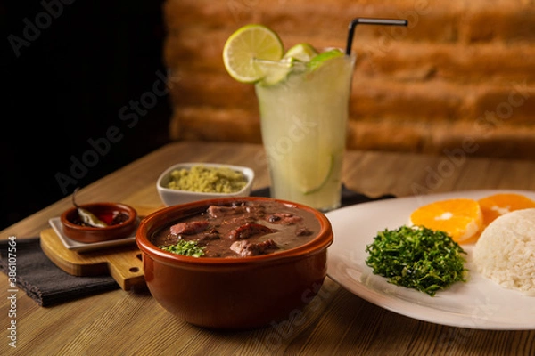 Fototapeta traditional Brazilian dish called feijoada, contains rice, beens, beef, pork, orange, vegetables
