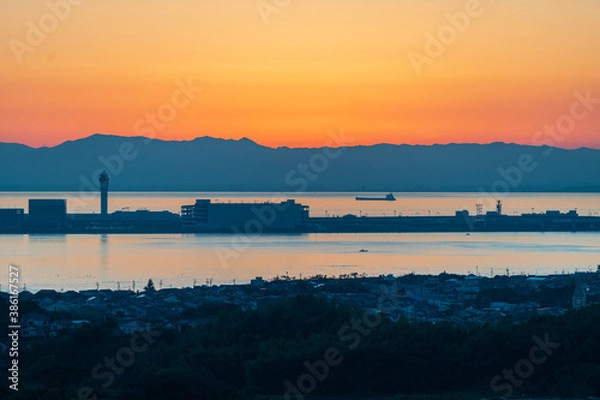 Fototapeta 樽水本宮神社から赤く焼けた綺麗な夕焼けと中部国際空港のシルエットを望む