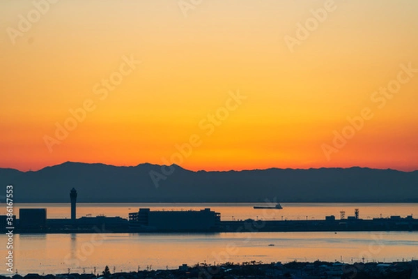 Obraz 樽水本宮神社から赤く焼けた綺麗な夕焼けと中部国際空港のシルエットを望む