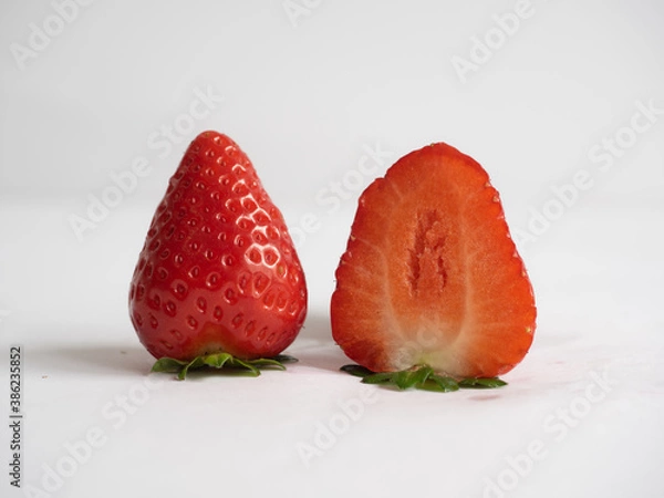 Fototapeta Close up of fresh strawberries - one of them is cut in half