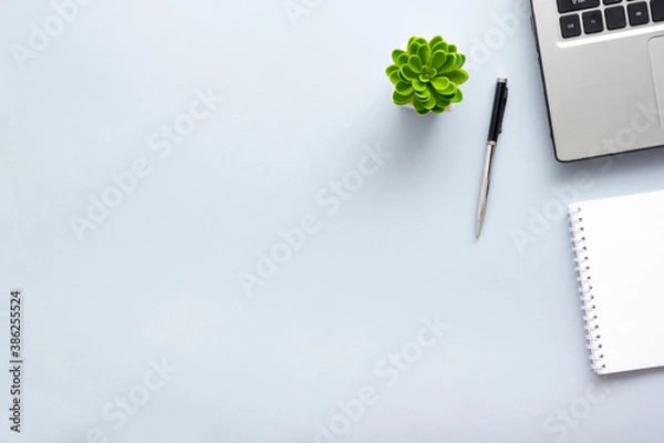 Fototapeta Blue desk office with laptop, smartphone and other work supplies with cup of coffee. Top view with copy space for input the text. Designer workspace on desk table essential elements on flat lay