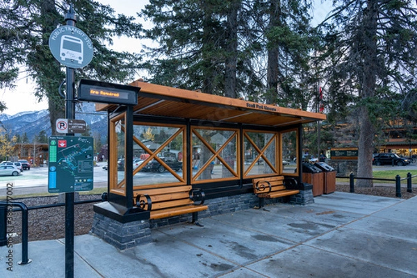 Fototapeta Street view of Town of Banff. Bus stop in Banff Avenue in autumn and winter snowy season. Banff, Alberta, Canada.