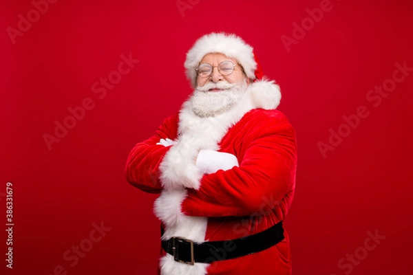 Fototapeta Photo of retired grandpa grey beard crossed hands self-assured smile wait elves prepare deer trip wear x-mas costume white gloves coat spectacles headwear isolated red color background
