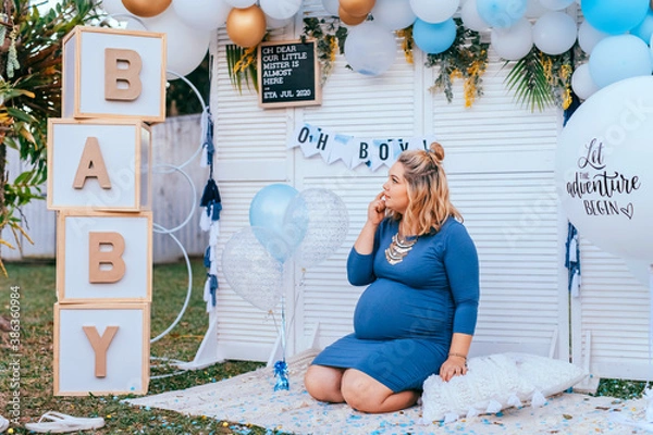 Obraz Baby shower - pregnant woman with a big tummy sits on the floor on a party setup