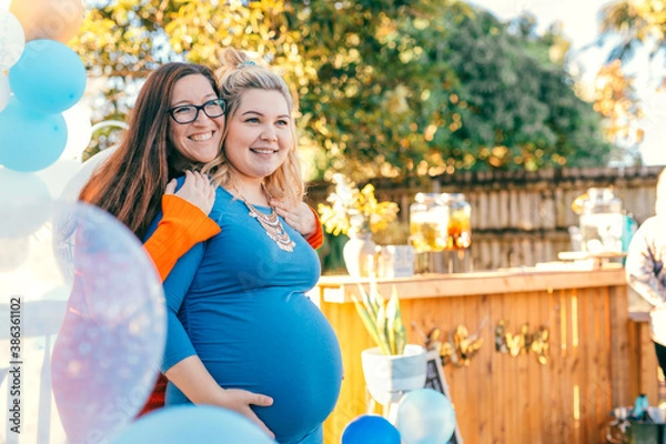 Obraz Pregnant woman with a friend hugging her on a Baby shower party setup.