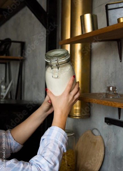 Obraz female hands holding a jar of flour